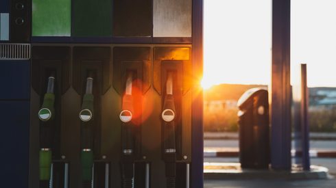 Fuel pump with dispensers located on gas station on sunny day on city street